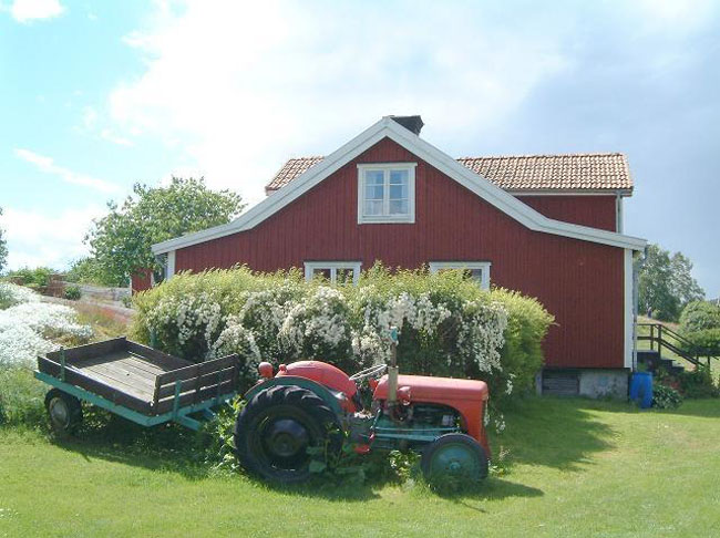 Traktor infront of an original Harstena house